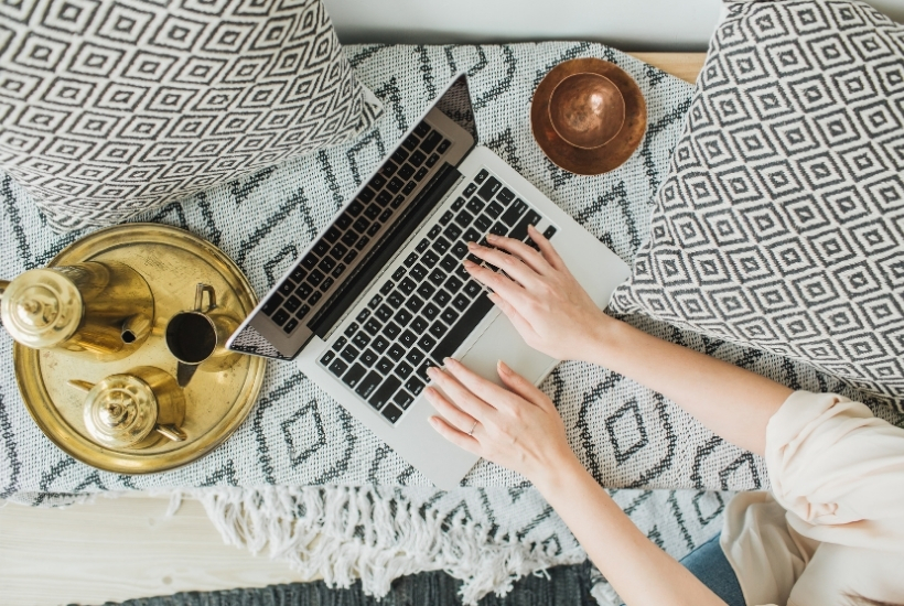 boho laptop flat lay in bed