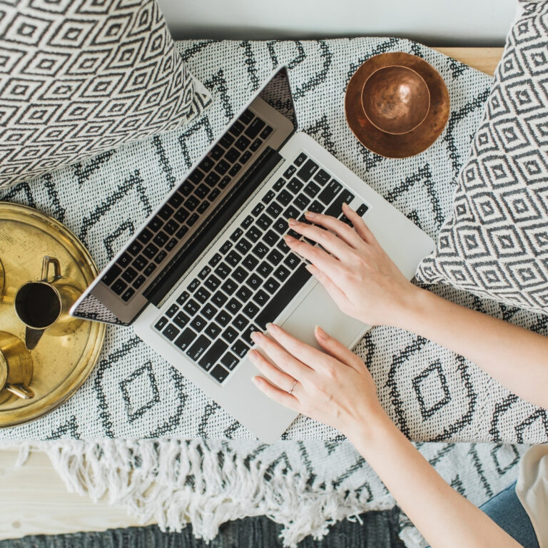 boho laptop flat lay in bed