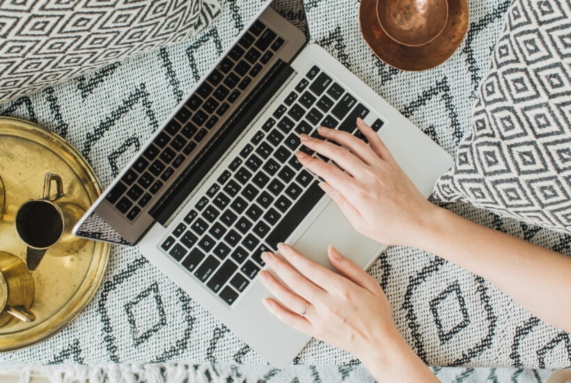 boho laptop flat lay in bed