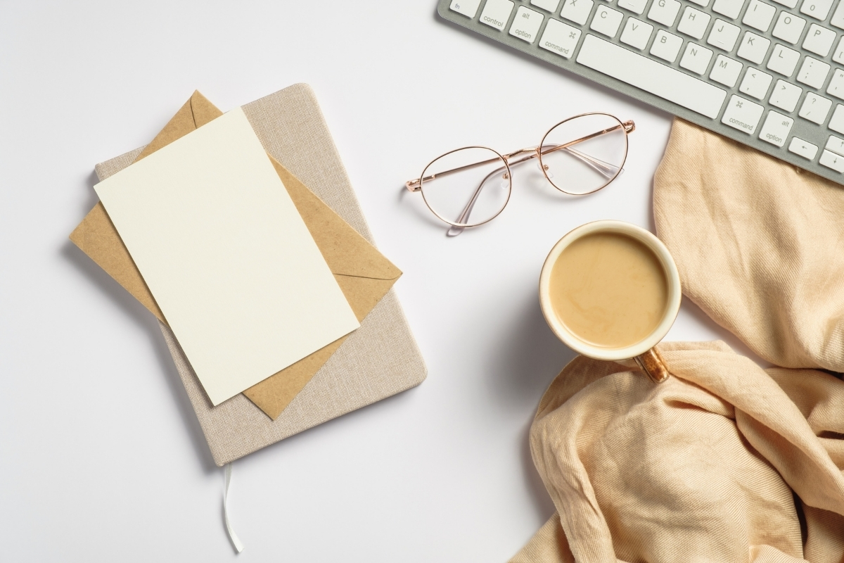 journal and cup of tea next to a white computer keyboard