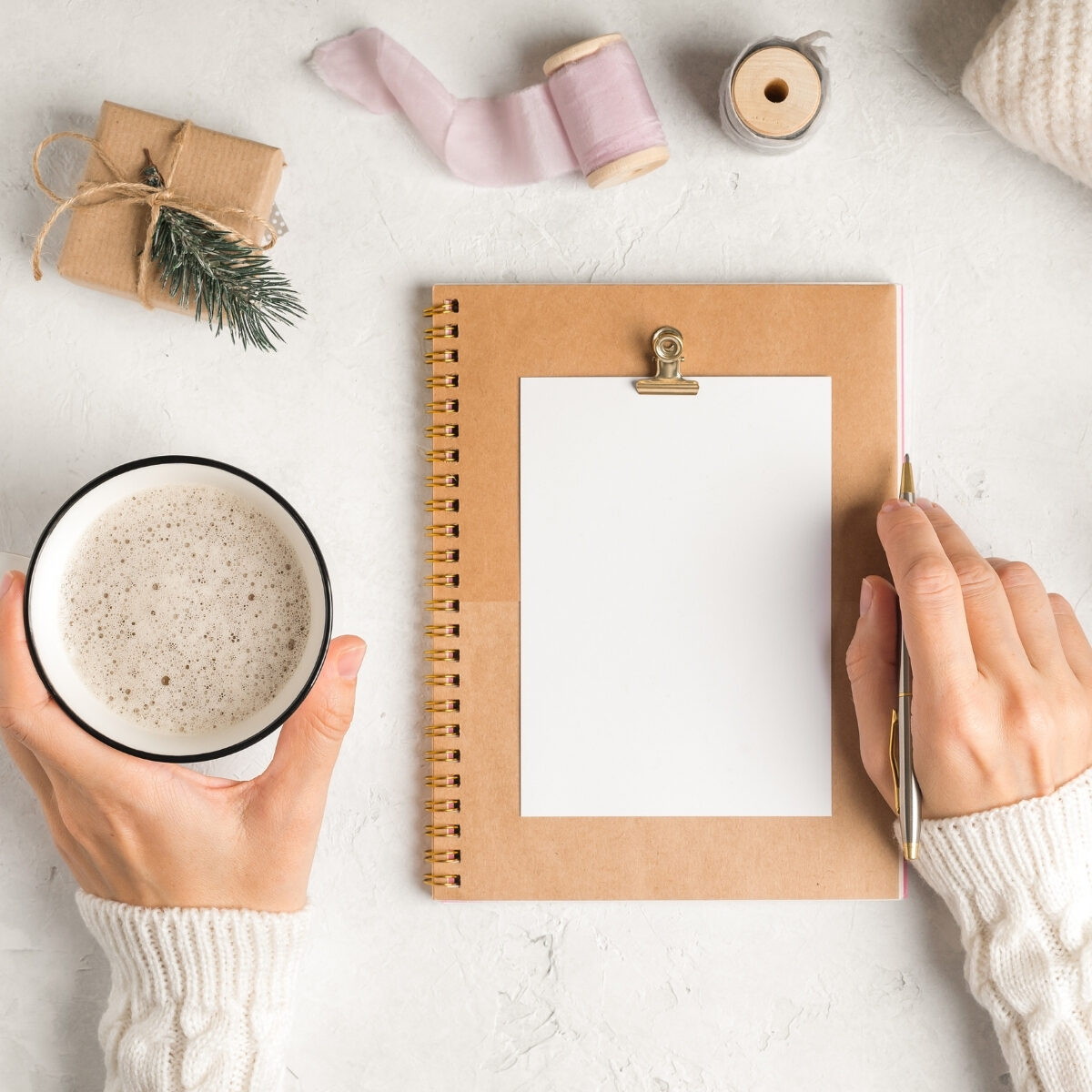 lady writing in notebook with a cup of coffee in hand