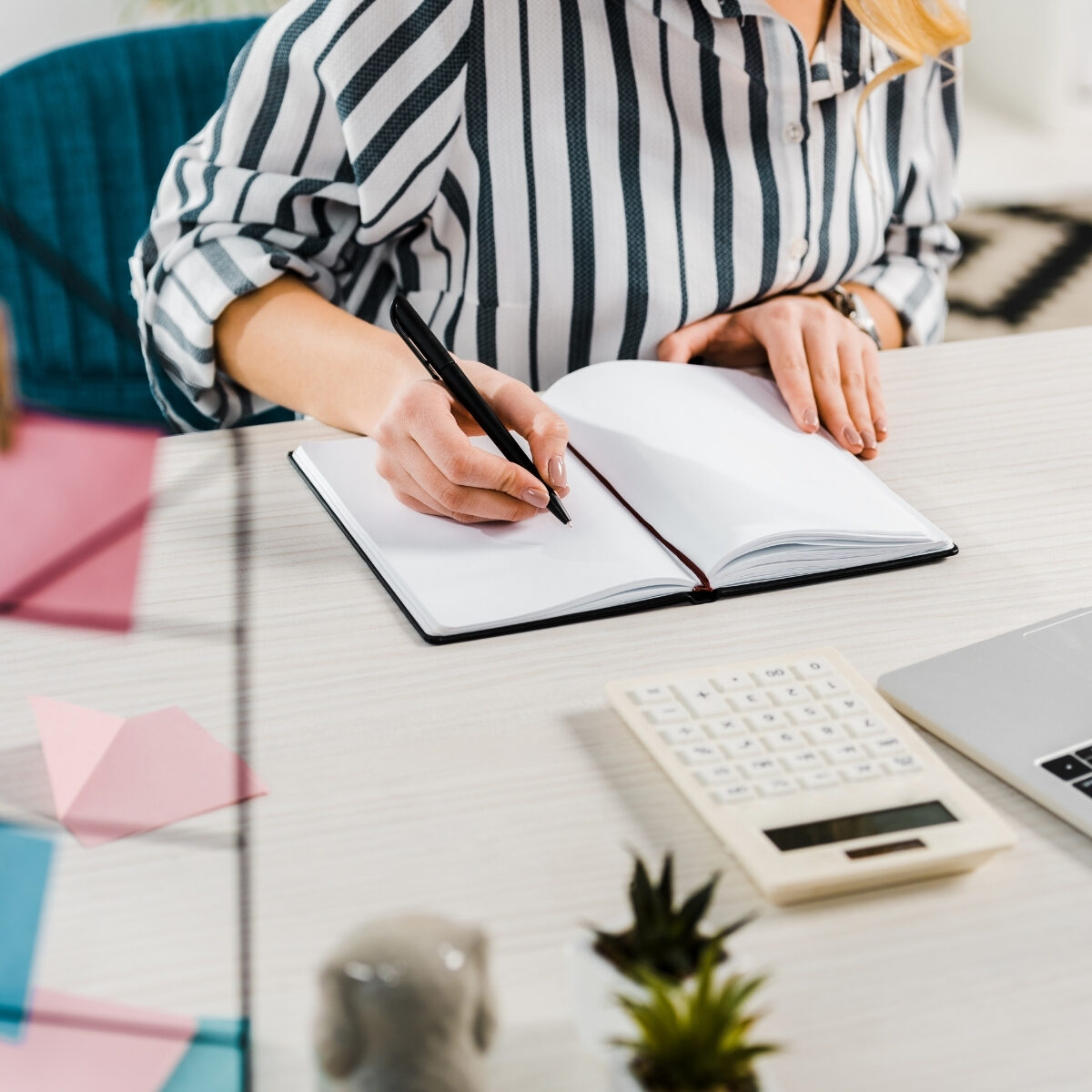 lady writing in a notebook at a desk in the office