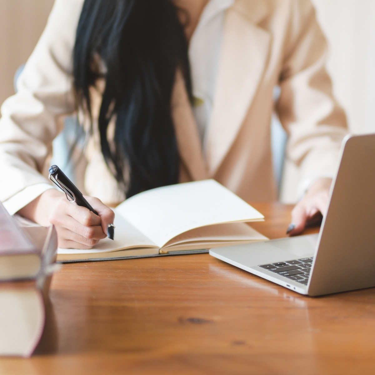 business lady using a laptop and writing in a notebook