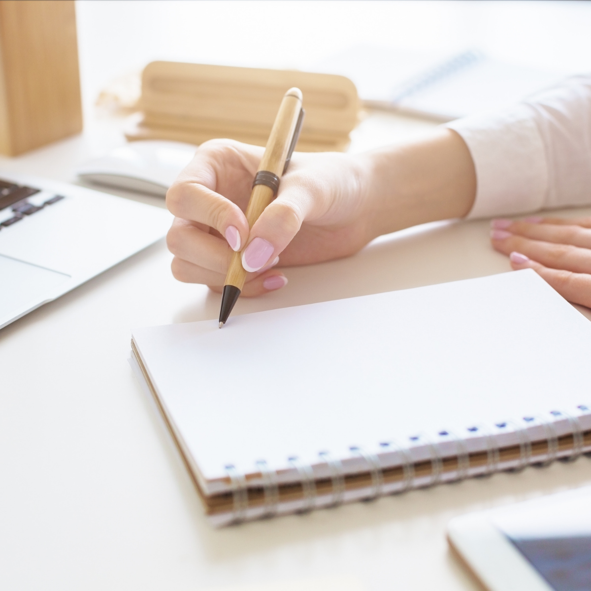 lady writing in a notebook at a desk