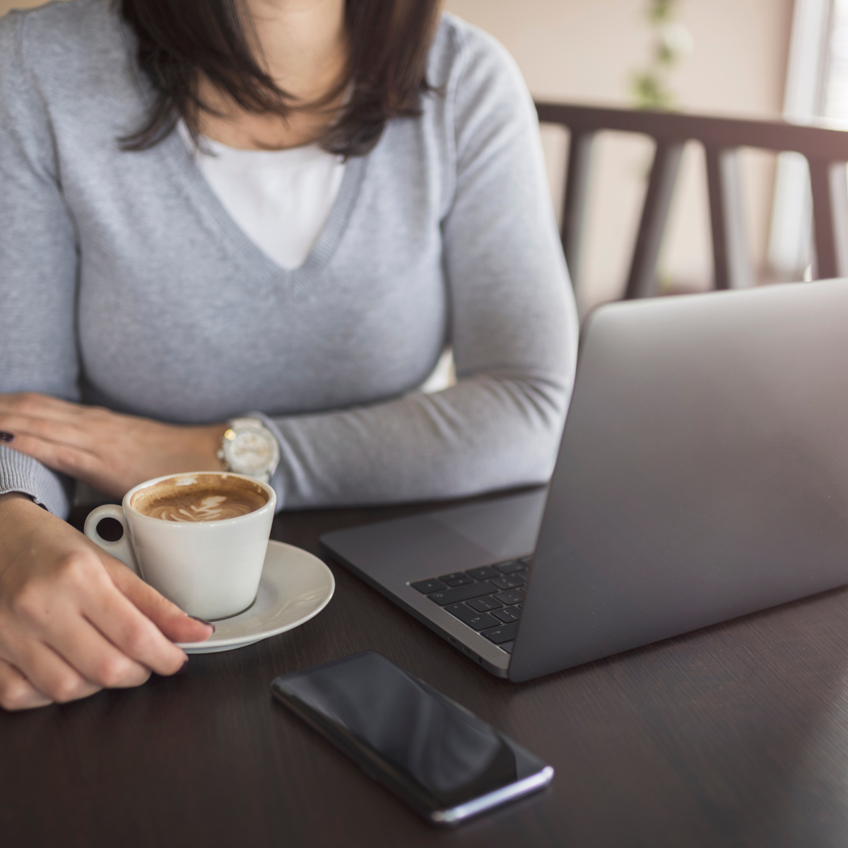 lady with a coffee cup and laptop at a coffee shop