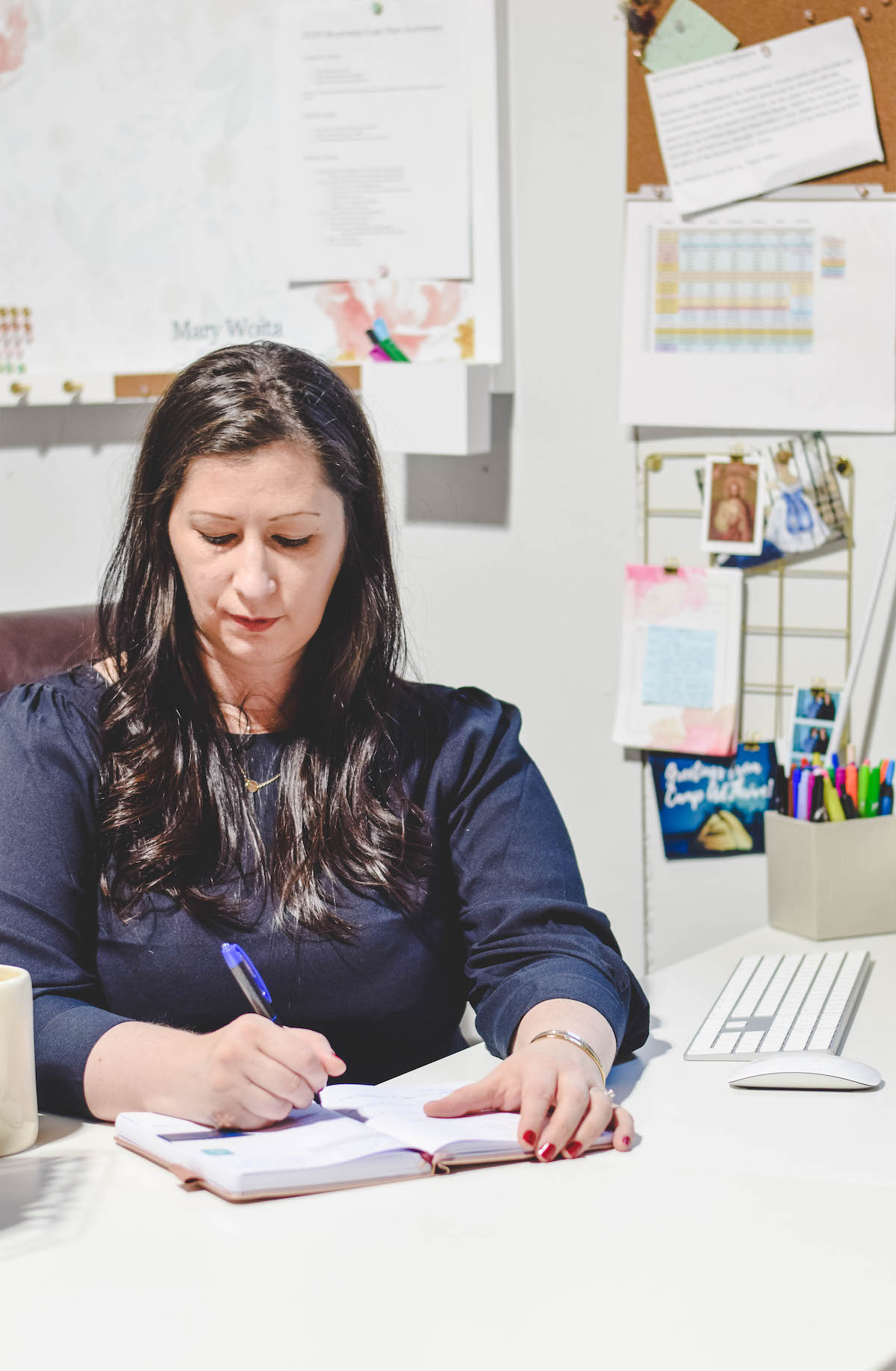writing in a planner at the desk